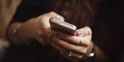 Mobile Menu image of a woman's hands typing on a mobile phone