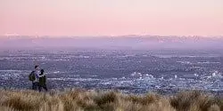 Image taken at dusk of two people looking down from the Port Hills over Christchurch - mobile