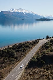 Aerial image of a road in the South Island with a lake and mountain in the background