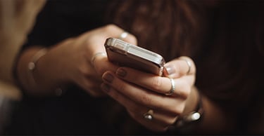 Woman's hands typing on a mobile phone