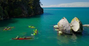 Aerial view of kayakers next to Nelson Split Apple Rock