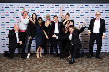 Image of GO Rentals team standing in front of a pink GO Rentals shuttle van