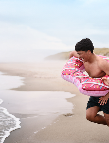 A boy and a girl are running into the sea for summer