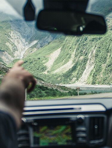 Image from the interior of a GO Rentals hire car heading down the winding slopes of a South Island mountain