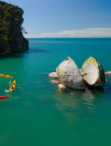 Image of people exploring and kayaking around the split apple rock in Nelson, Tasman, New Zealand