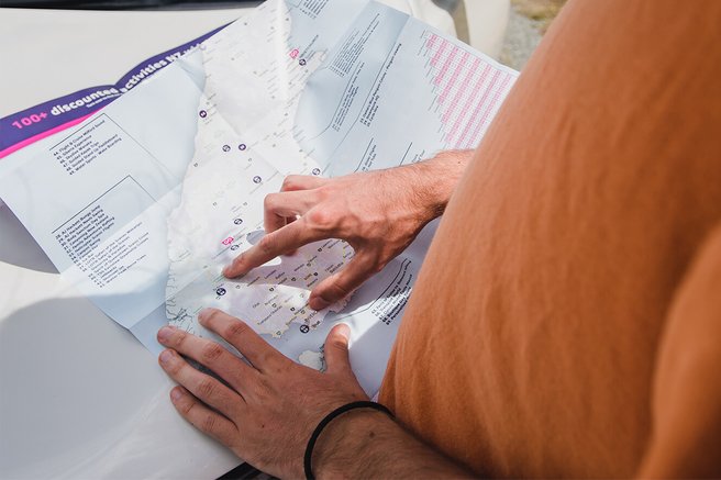 Close up image of hands exploring a map of New Zealand
