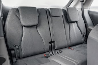Interior image of the rear of a Kia Carnival Hybrid showing the three back seats