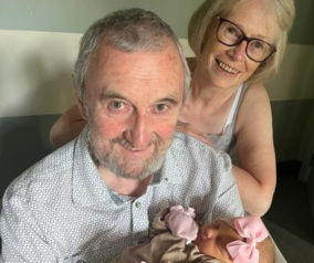 Lesley and partner holding a baby 