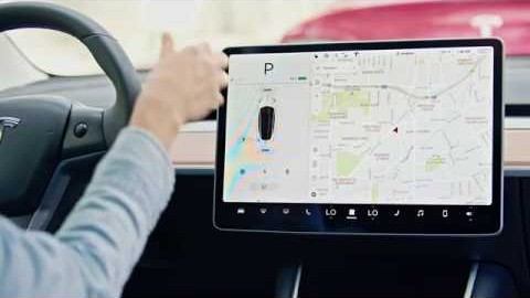 An interior photo of Tesla Model 3 with a person driving