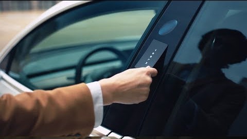 A persona opening a Tesla Model 3 with a key card