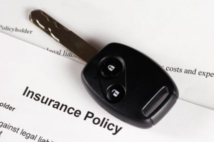 Car key on an insurance policy document