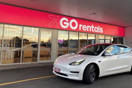 White Tesla Model 3 parked outside a GO Rentals branch