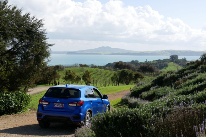Photo of Waiheke Island in the background with GO Rentals vehicle in the foreground