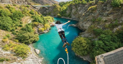 Person bungee jumping over a turquoise river
