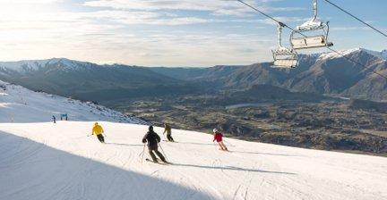 Skiers on a snowy slope with mountain views