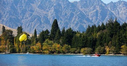 Parasailing over a lake with mountain backdrop