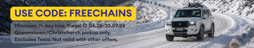 White SUV driving on a snowy mountain road with code FREECHAINS promo text