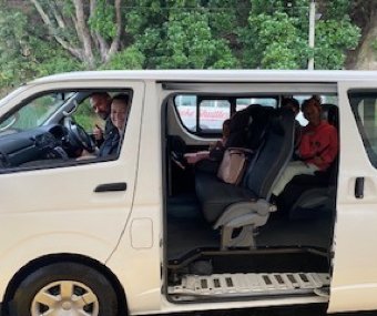 People sitting inside a white van with the sliding door open