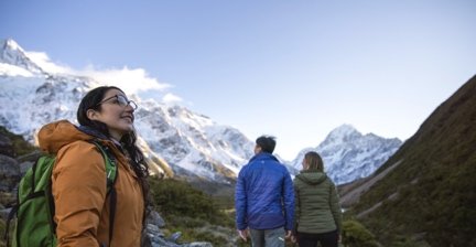 Hikers walking toward snowy peaks in Mount Cook National Park
