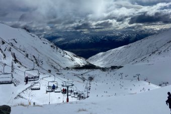 Snowy mountain ski resort with ski lifts and people skiing