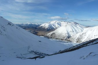 Scenic view of snow-covered mountains with a winding road below