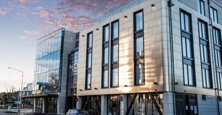 Modern facade of Sudima Christchurch City hotel reflecting the evening light