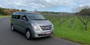 Image of a Hyundai iMax People Carrier parked up at a New Zealand vineyard with rows of vines in the background