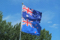 New Zealand flag waving against a clear blue sky