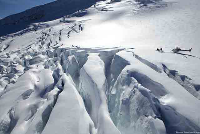 Image of people being dropped of by helicopter above the Franz Josef glacier to take a heli-hike down onto the ice