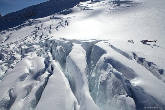 Image of people being dropped of by helicopter above the Franz Josef glacier to take a heli-hike down onto the ice