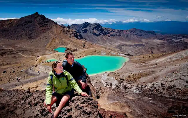 Image of people walking the Tongariro Alpine Crossing in the Tongariro National Park with the emerald lakes in the background