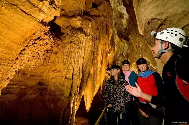 Image of a guide showing people around the Waitomo Caves