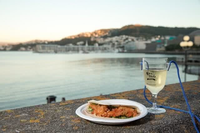 Image of a Wellington Wine and Food Festival glass, plate and stunning harbour view