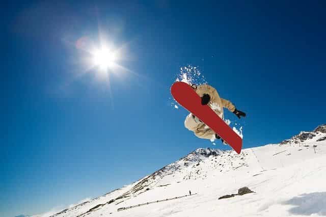 Image of A snowboarder takes off on the slopes of Cardrona near Queenstown and Wanaka