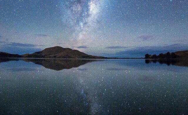 Starry night sky over a lake