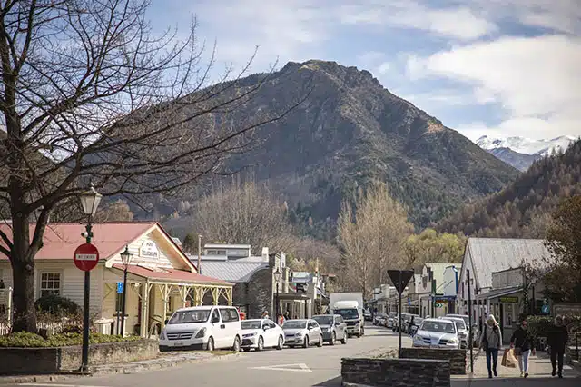 a small town road with a mountain in the background