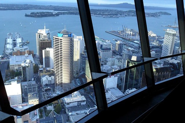city buildings and the harbour as seen from the viewing room of the Auckland Sky Tower - with Rangitoto Island in the distance