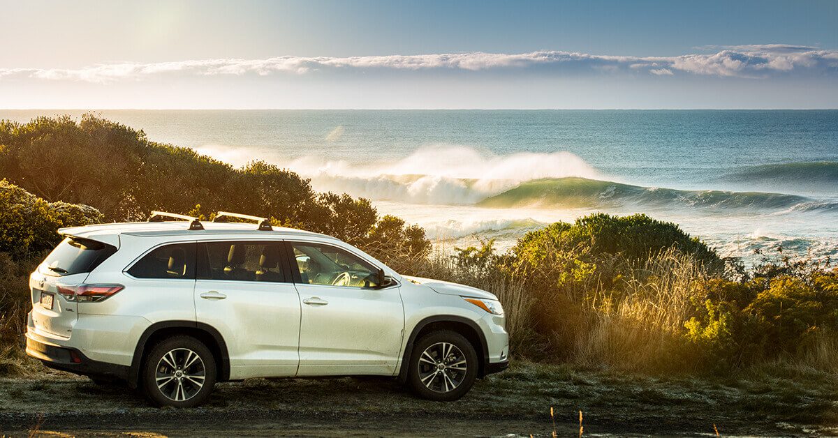 Image of a Toyota Highlander parked up next to the beach