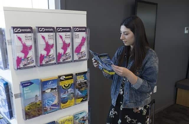 A young female looking at brochures in a GO Rentals branch