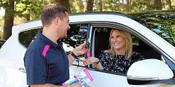 GO Rentals team member handing over the keys to a new rental car to a smiling customer