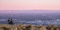 Image taken at dusk of two people looking down from the Port Hills over Christchurch - mobile