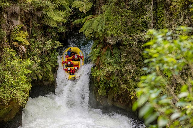 group in yellow inflatable raft going down a small waterfall