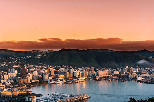 City waterfront with an orange sunset over the hills in the background