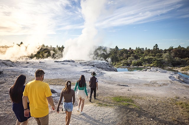 a tour guide leading a family through the geysers 