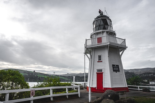 three story red and white lighthouse in akaroa