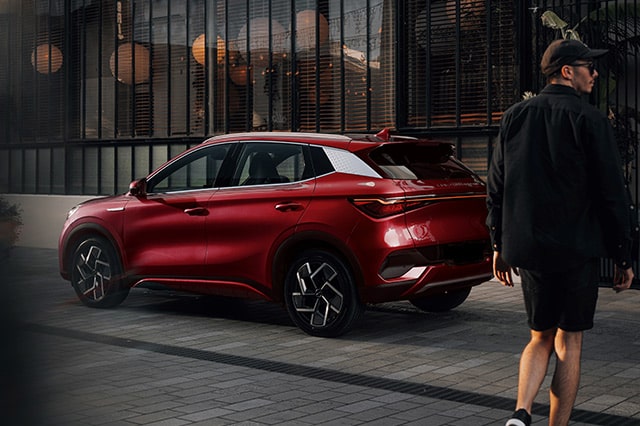 male person next to a BYD Atto 3 parked in city