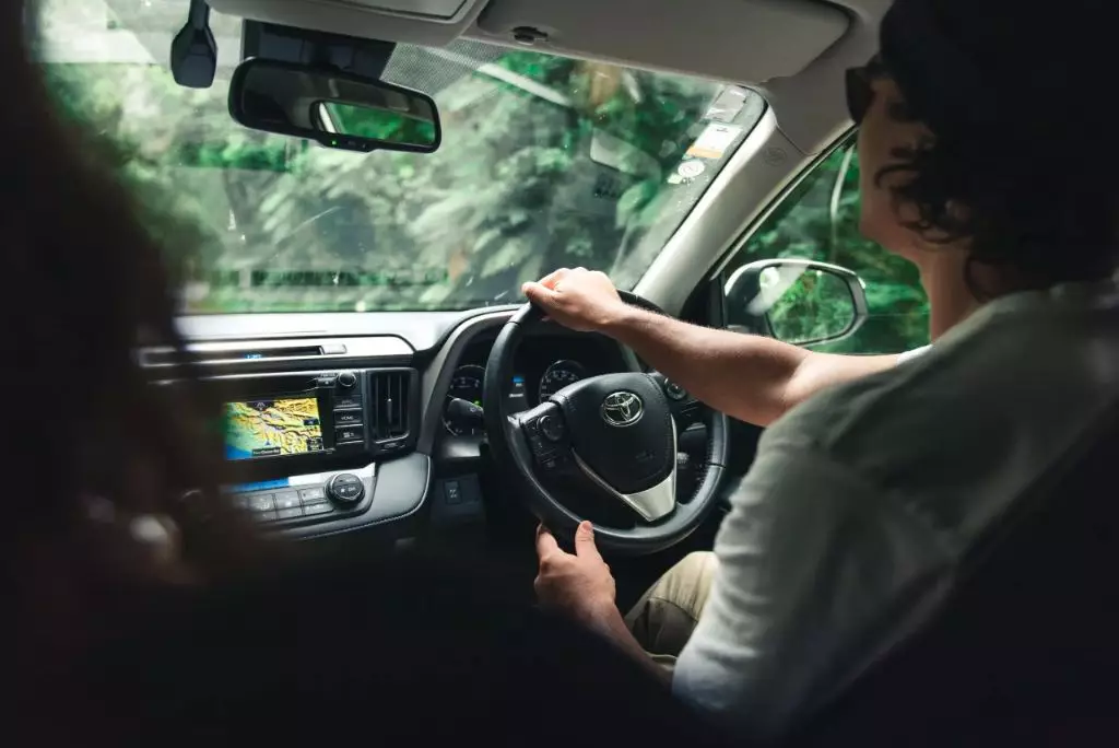 view inside a vehicle of driver sitting on the right driving in new zealand