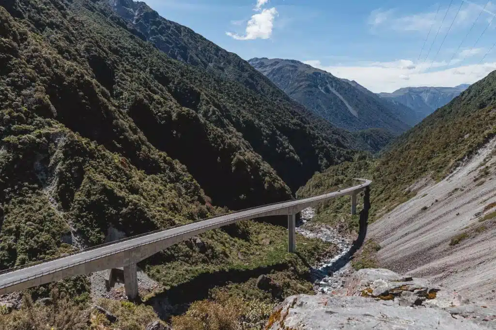 car driving on new zealand arthur's pass road with mountain landscape